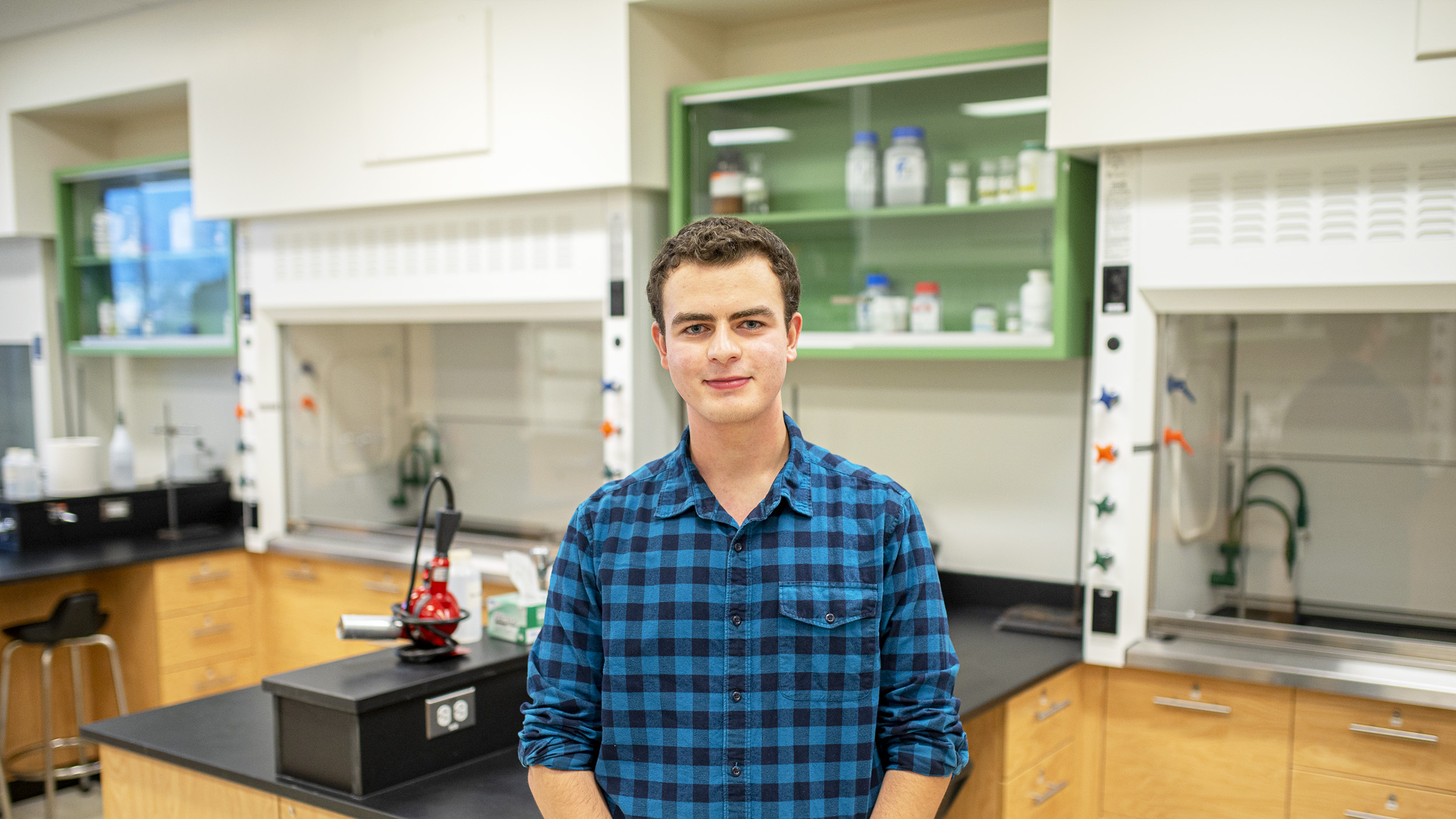 Un étudiant se tient debout dans un laboratoire de sciences