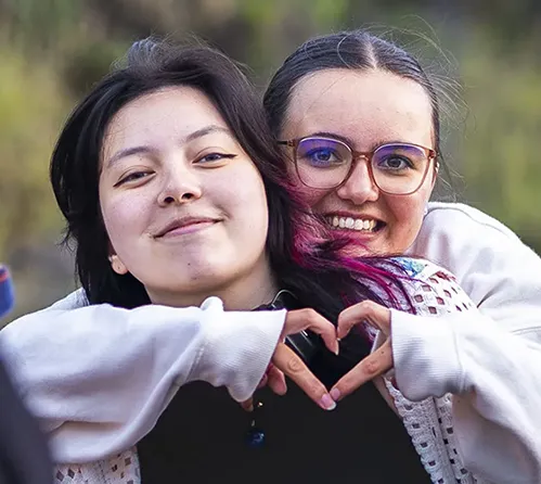 2 étudiantes qui forment un coeur avec les mains.