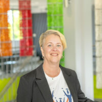 France Henry, la nouvelle directrice générale de la Fondation du Cégep de Matane, pose devant la caméra dans le hall du cégep pour annoncer son entrée en poste.