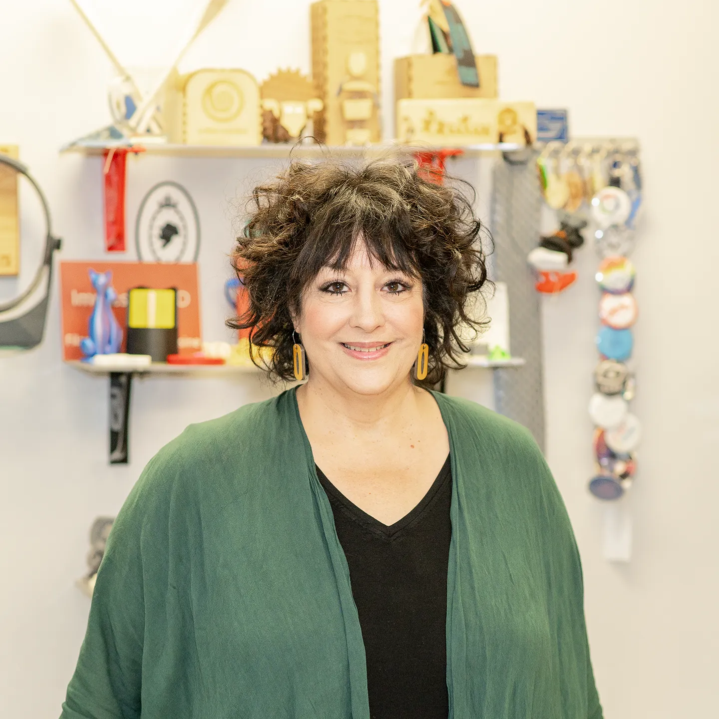 Sylvie Theriault, la nouvelle apparitrice du Fablab, prend la pose pour annoncer son arrivée dans ce laboratoire de création numérique dont on voit quelques objets en arrière-plan.