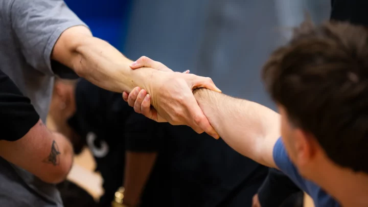 Un gros plan sur deux personnes qui se tiennent par le bras lors d'une épreuve sportive.