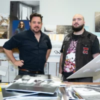 Deux personnes se tiennent dans la salle d'archivage du Département de photographie, avec des images des cohortes précédentes à sélectionner pour un affichage ultérieur.