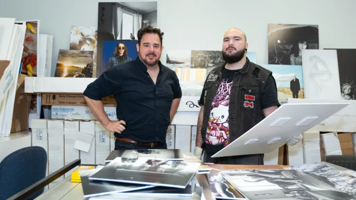 Deux personnes se tiennent dans la salle d'archivage du Département de photographie, avec des images des cohortes précédentes à sélectionner pour un affichage ultérieur.